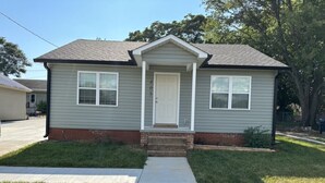A single-story house with a front door, two windows on the first floor, a small front porch, and a sidewalk leading to the entrance. - Holy Holt of Lexington nc (Lexington)