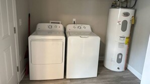 A laundry room with two front-loading washers and a tall water heater. - Holy Holt of Lexington nc (Lexington)