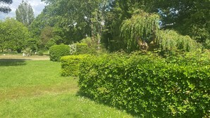 A well-maintained garden with neatly trimmed hedges and a variety of trees. - Appartement Plage et Lac, 4pieces 3 Chambres (Les Sables-d'Olonne)