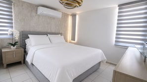 A modern bedroom with a bed, bedside table, and an air conditioning unit.