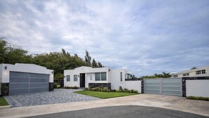 A modern two-story house with a garage, a driveway, and a well-maintained lawn.
