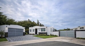 Une maison moderne à deux étages, dotée d’un garage, d’une allée et d’une pelouse bien entretenue.