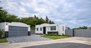 A modern two-story house with a garage, a well-maintained lawn, and a stone accent wall.