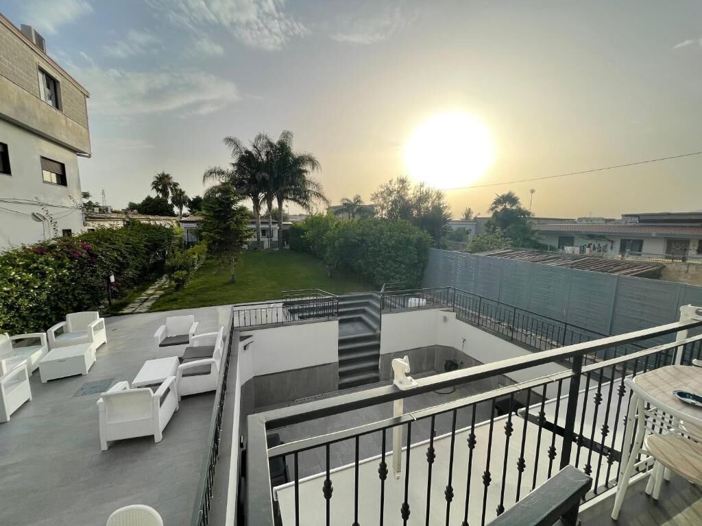 Una terraza en la azotea con mobiliario exterior y vistas a la puesta de sol.