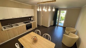 Una cocina moderna con zona de comedor, horno empotrado y un amplio ventanal.