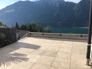 Un balcon avec vue sur un lac et des montagnes.