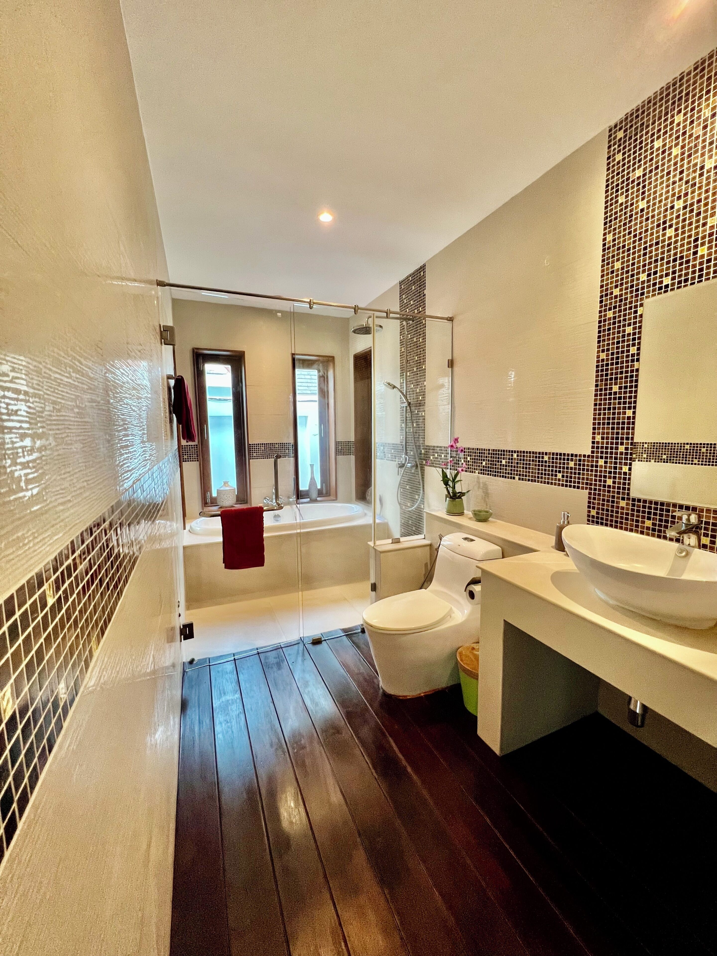Une salle de bain moderne avec une baignoire, des toilettes et deux lavabos.
