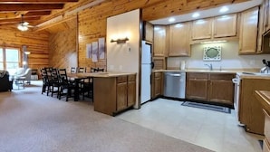 A cozy cabin-style interior with a dining area, kitchen, and living space.