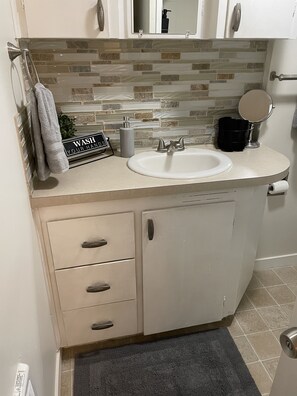 A bathroom with a sink, towel rack, cabinet, and a mirror. - Cozy home close to historic Washburne District, Hospital, Autzen Stadium!  (Springfield)