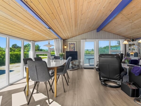 Un intérieur moderne comprenant un coin repas, un téléviseur et un balcon avec vue.