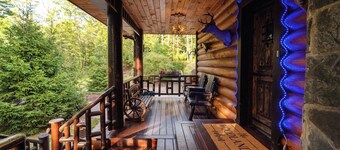 Private log cabin nestled at the base of a secluded wooded area 
