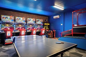 A room with a ping pong table, multiple Nintendo 64 arcade machines, and a red and blue play area. - The Best Home's Resort Orlando (Kissimmee)