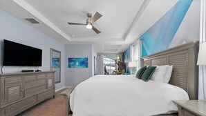 A bedroom with a large bed, a flat-screen TV, a dresser, and a ceiling fan. - The Best Home's Resort Orlando (Kissimmee)