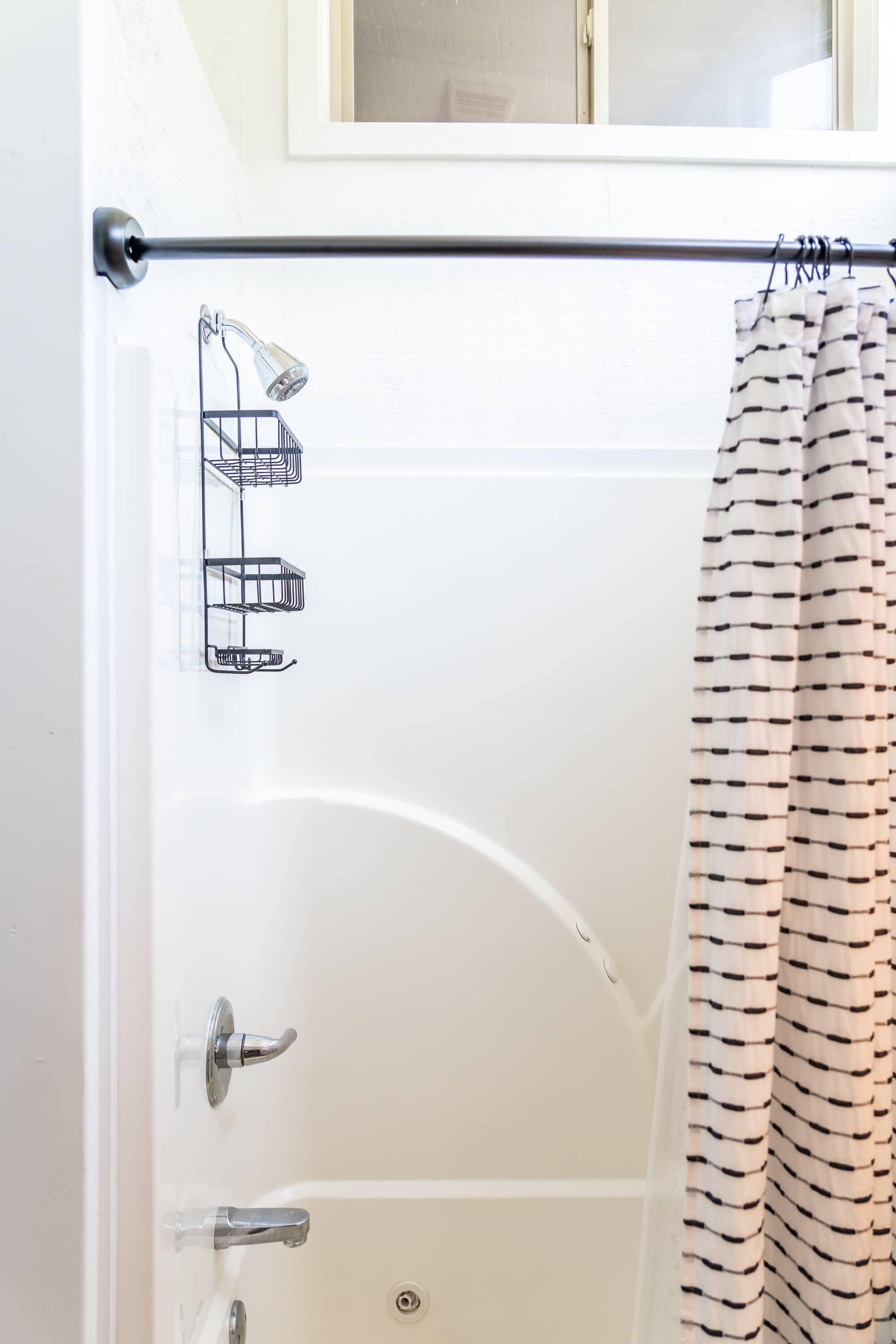 A bathroom with a bathtub, a shower, and a towel rack.