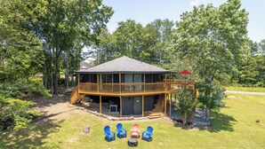 A two-story house with a deck, outdoor seating, and a covered area. - Unique Octagon Home near Hot Springs (Hot Springs)