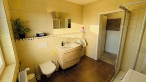 Een badkamer met toilet, wastafel en douche.