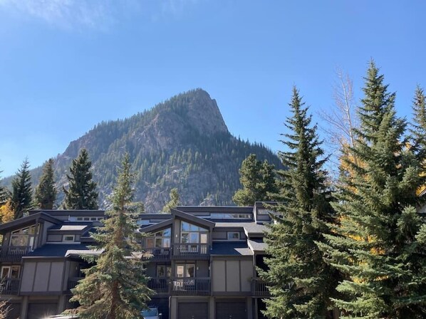 A multi-story hotel with a mountain backdrop.
