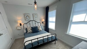 A bedroom with a bed, bedside lamps, a window, and a ceiling light fixture. - Downtown Villa - steps from the heart of Waxhaw (Waxhaw)