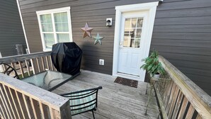 A wooden deck with a covered table and chair, a door, and a star decoration. - Downtown Villa - steps from the heart of Waxhaw (Waxhaw)