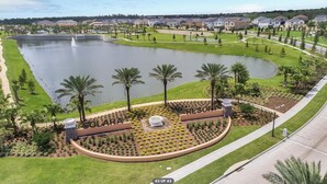Un complexe hôtelier doté d’un étang central, de palmiers et d’une pelouse bien entretenue.