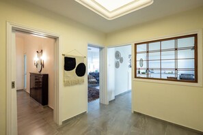 A hallway with a modern kitchen area, a dining area, and a living room.