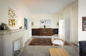 Una sala de estar con chimenea, un mueble de madera, un sillón y un sofá.