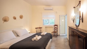 A hotel room with a bed, a chair, a desk, and a mirror. - Your 2BR Green Oasis — Steps from Rabin Square (Tel Aviv)