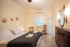Una habitación de hotel con una cama, una silla, un escritorio y un espejo.