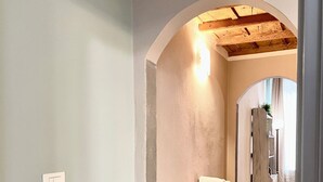 A hallway with a wooden bench, a towel rack, and a light fixture. - APARTMENT 'ORCHID' WHIT ONE BEDROOM.  (Firenze)
