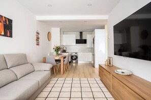 A modern apartment with a living room, dining area, and kitchen.