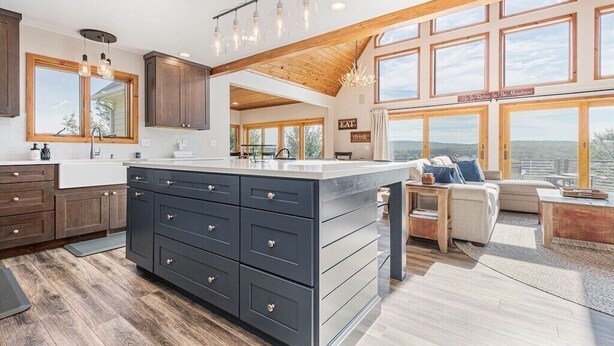A spacious kitchen with dark cabinets, a large island, and a dining area with a view. - Great VIEWS! 10 mins to WISP, boat dock, hot tub, dog friendly, golf course. (Swanton)