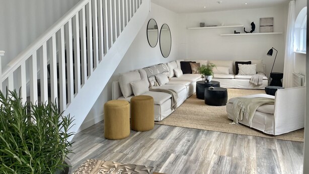 Uma sala de estar moderna com escada, um sofá e uma mesa de centro.