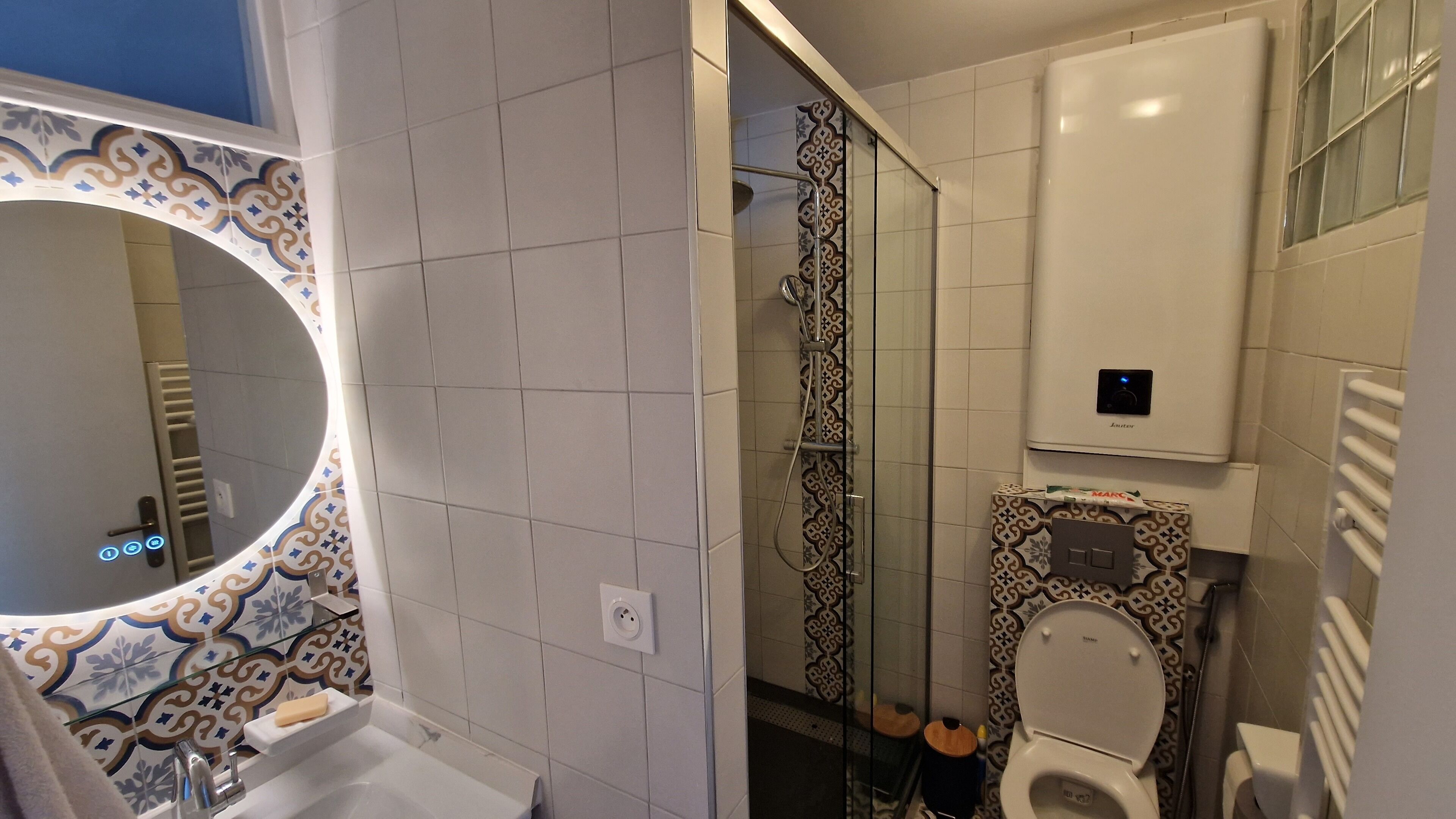 Et badeværelse med brusebad, toilet og håndvask.