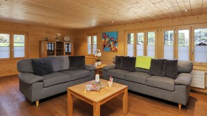Un interno in legno con due divani grigi, un tavolino in legno e un quadro appeso al muro.