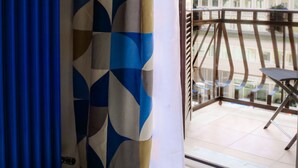 A room with a view of a building through a window with a curtain. - Lele Rooms Termini (Rome)