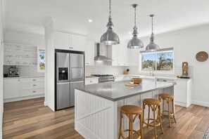 Enjoy cooking in this well-lit kitchen with a large island and stainless steel appliances.