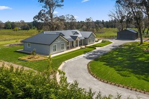 Stunning two-story home with a well-manicured lawn and a charming garden.