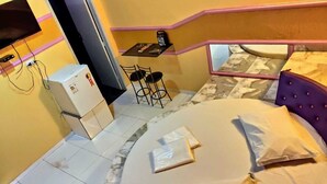 A compact room with a bed, a small table, and two chairs. - HOTEL PARAÍSO  (Guaira)