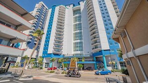 A multi-story hotel with a modern design, featuring balconies and a central atrium.