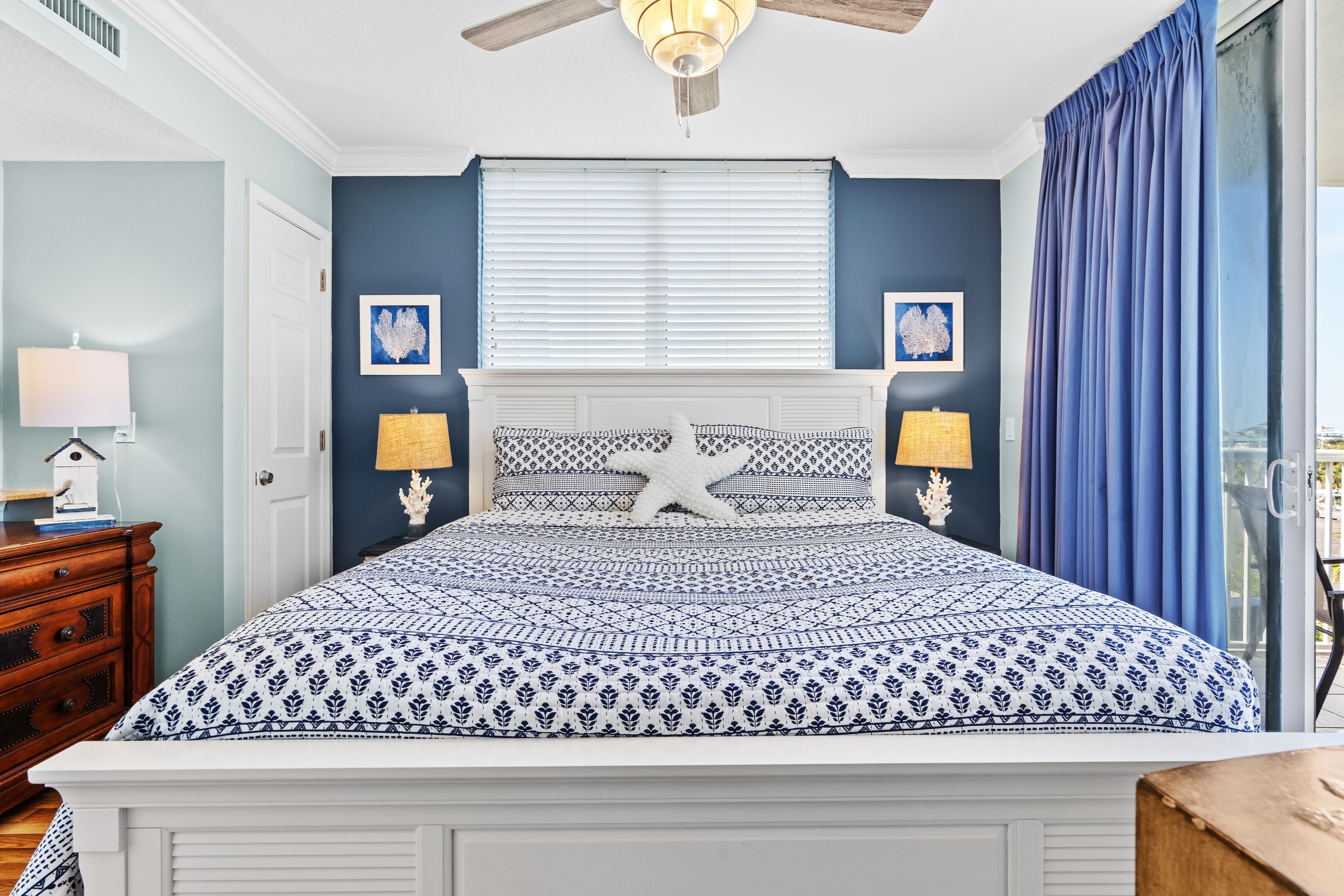 A bedroom with a bed, a nightstand, a lamp, and a ceiling fan.