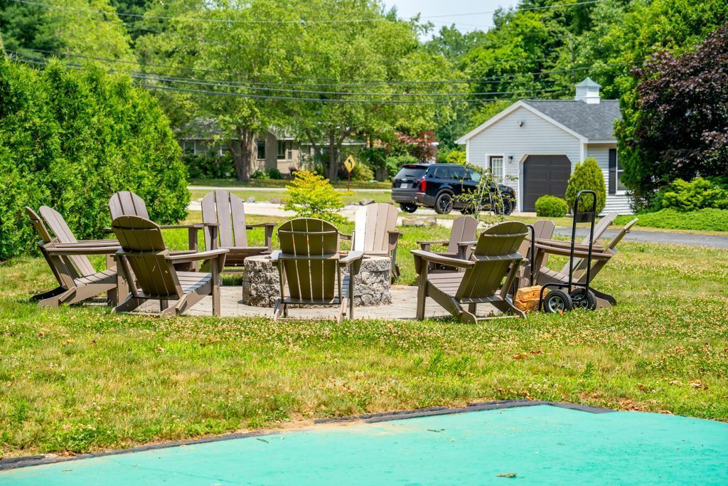 A backyard with a pool, outdoor furniture, and a garage.