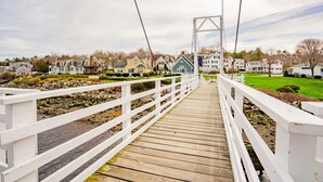 A wooden bridge with white railings leading to a row of houses. - Shamrock by the Sea Hot Tub Arcade Basketball Court & Beach Fun (Wells)