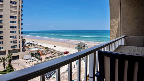 Un balcon avec vue sur une plage et sur le poste de surveillance des sauveteurs.