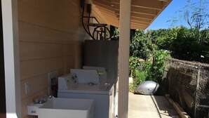 A covered outdoor area with a washing machine and dryer, a concrete floor, and a chain-link fence in the background. - 2bedrm/1bathrm, near shopping center and freeway  (Honolulu)