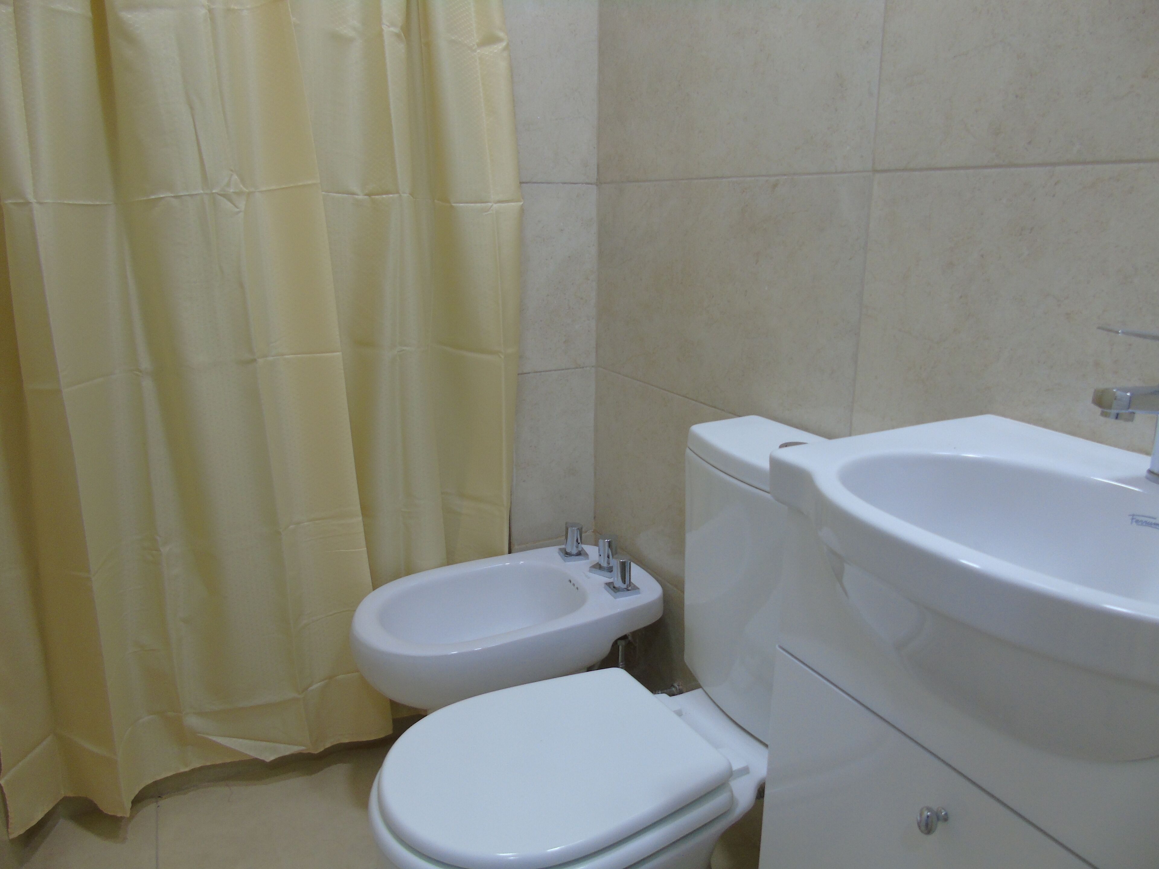 Un baño con inodoro, lavabo y bidé.