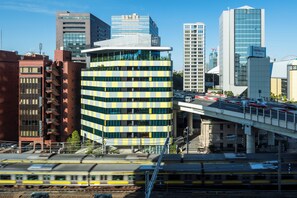 A modern urban skyline with high-rise buildings, including a prominent yellow and blue building with a curved facade. - toggle hotel suidobashi TOKYO (Tokyo)