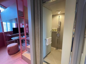 A modern hotel room with a seating area, a television, and a shower. - toggle hotel suidobashi TOKYO (Tokyo)