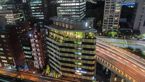 A multi-story building with a distinctive checkered facade, a rooftop garden, and a visible parking area. - toggle hotel suidobashi TOKYO (Tokyo)