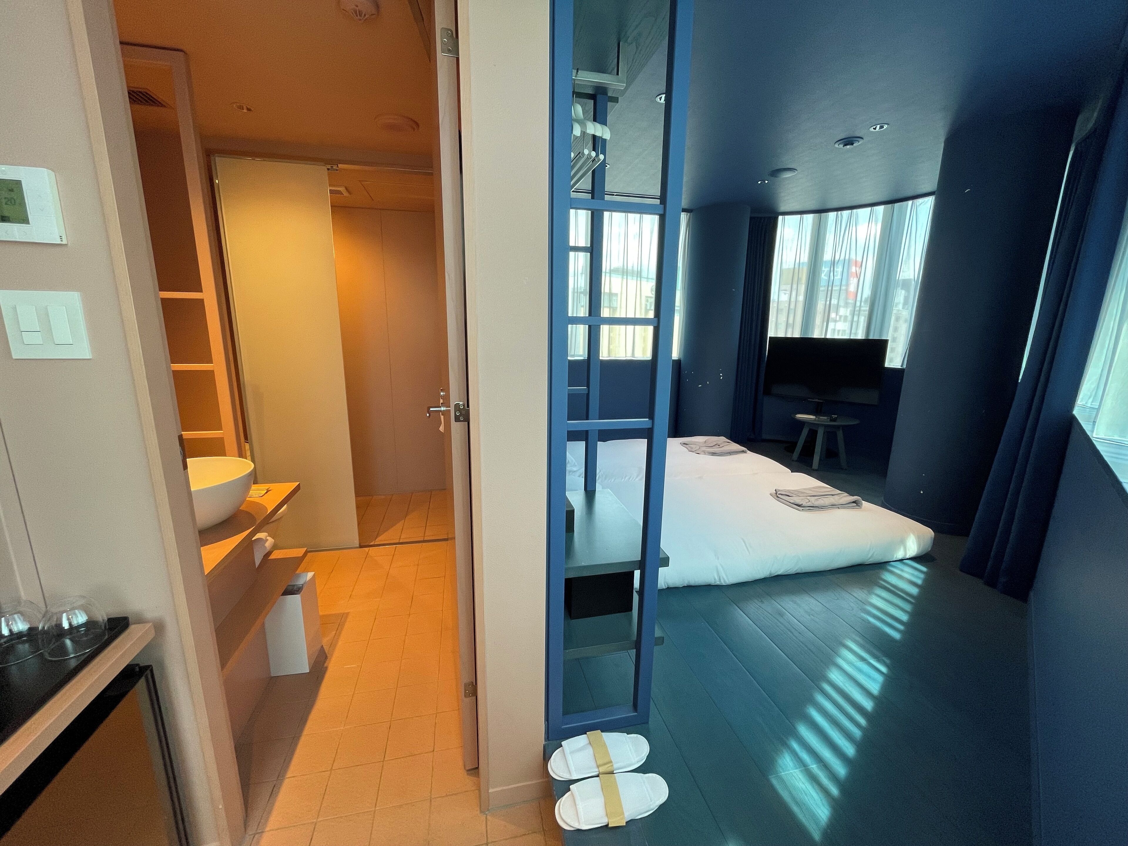 Ein modernes Hotelzimmer mit Bett, Schreibtisch und Badezimmer.
