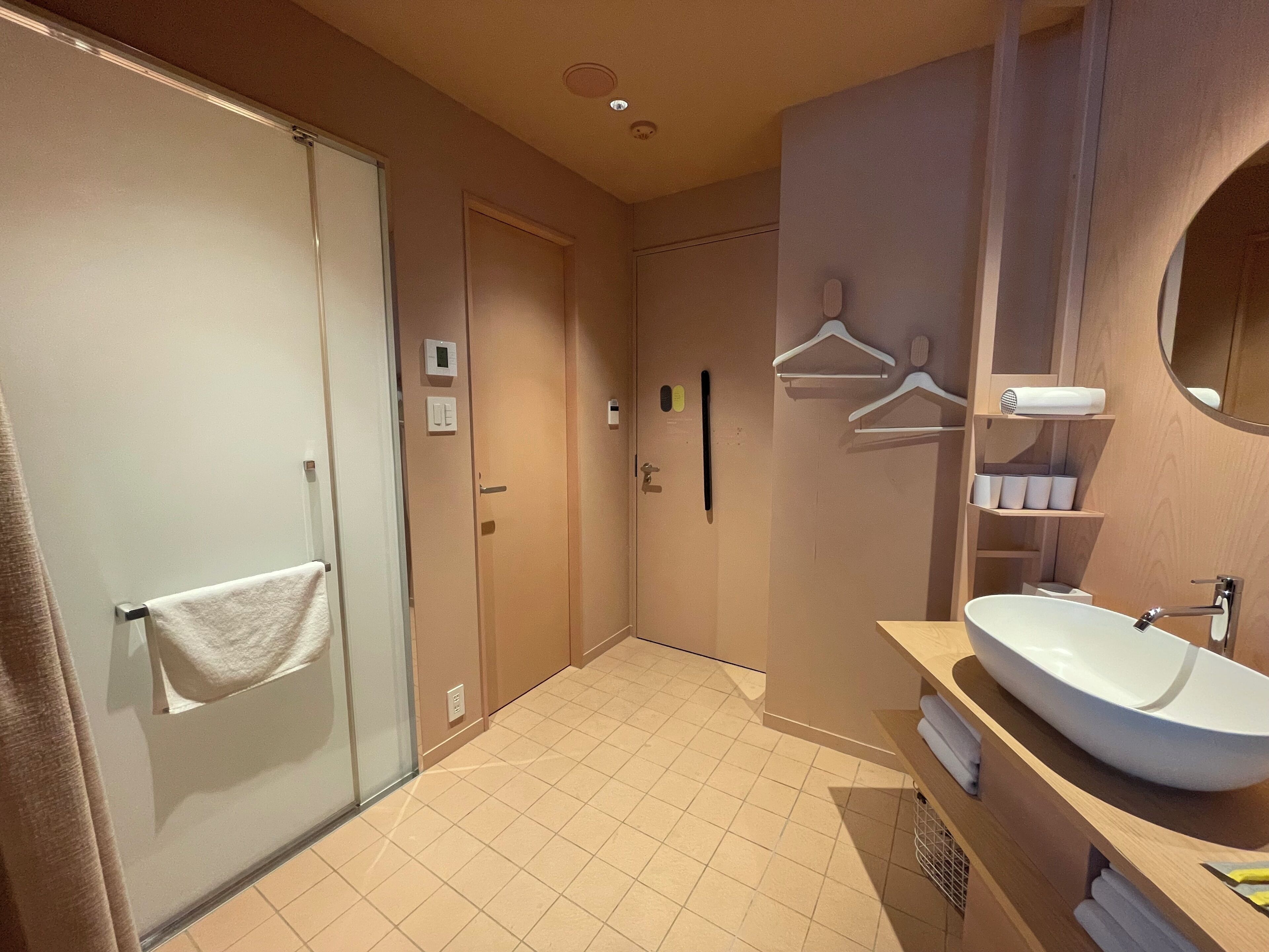 A modern bathroom with a large sink, towel rack, and a mirror.